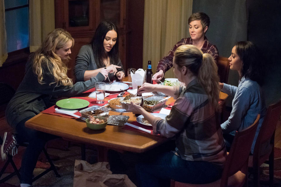 The characters sitting around a table eating