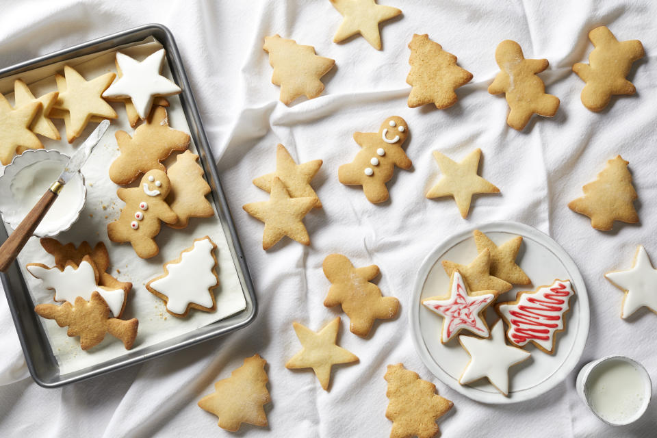 Christmas sugar cookies being iced, overhead view