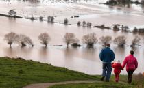 GLASTONBURY, UNITED KINGDOM - NOVEMBER 25: People walk from Glastonbury Tor as flood water in the fields below is seen, on November 25, 2012 in Somerset, England. Another band of heavy rain and wind continued to bring disruption to many parts of the country today particularly in the south west which was already suffering from flooding earlier in the week. (Photo by Matt Cardy/Getty Images)