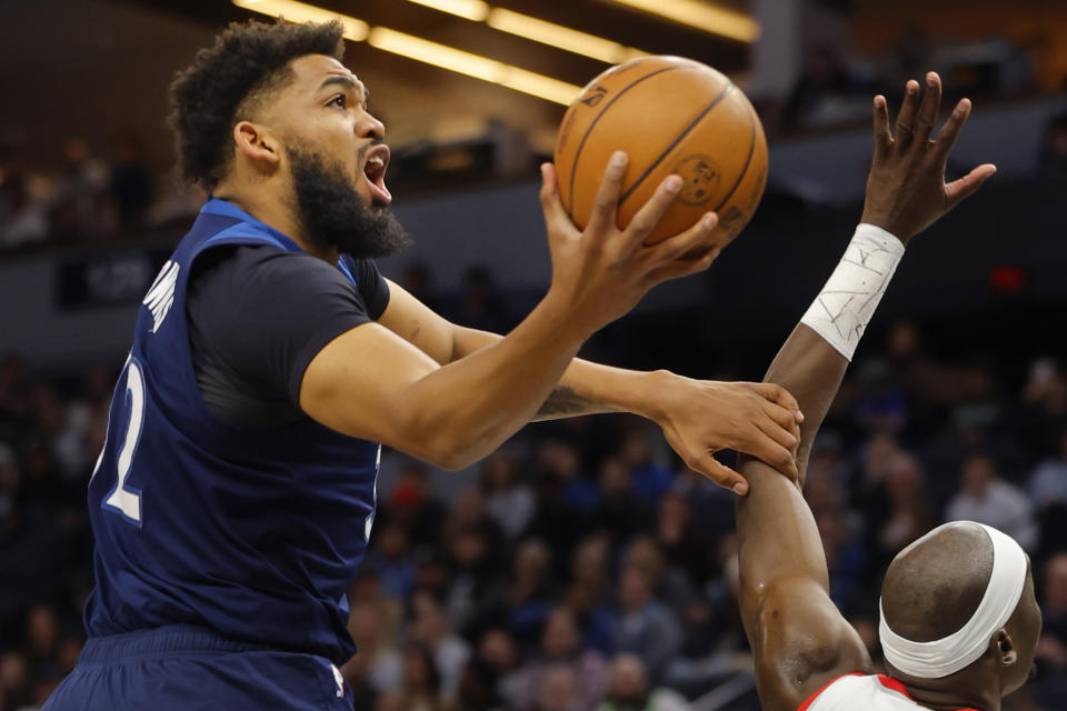 Minnesota Timberwolves forward Karl-Anthony Towns, left, goes to the basket against the Portland Trail Blazers in the first quarter of an NBA basketball game Monday, March 4, 2024, in Minneapolis. (AP Photo/Bruce Kluckhohn)