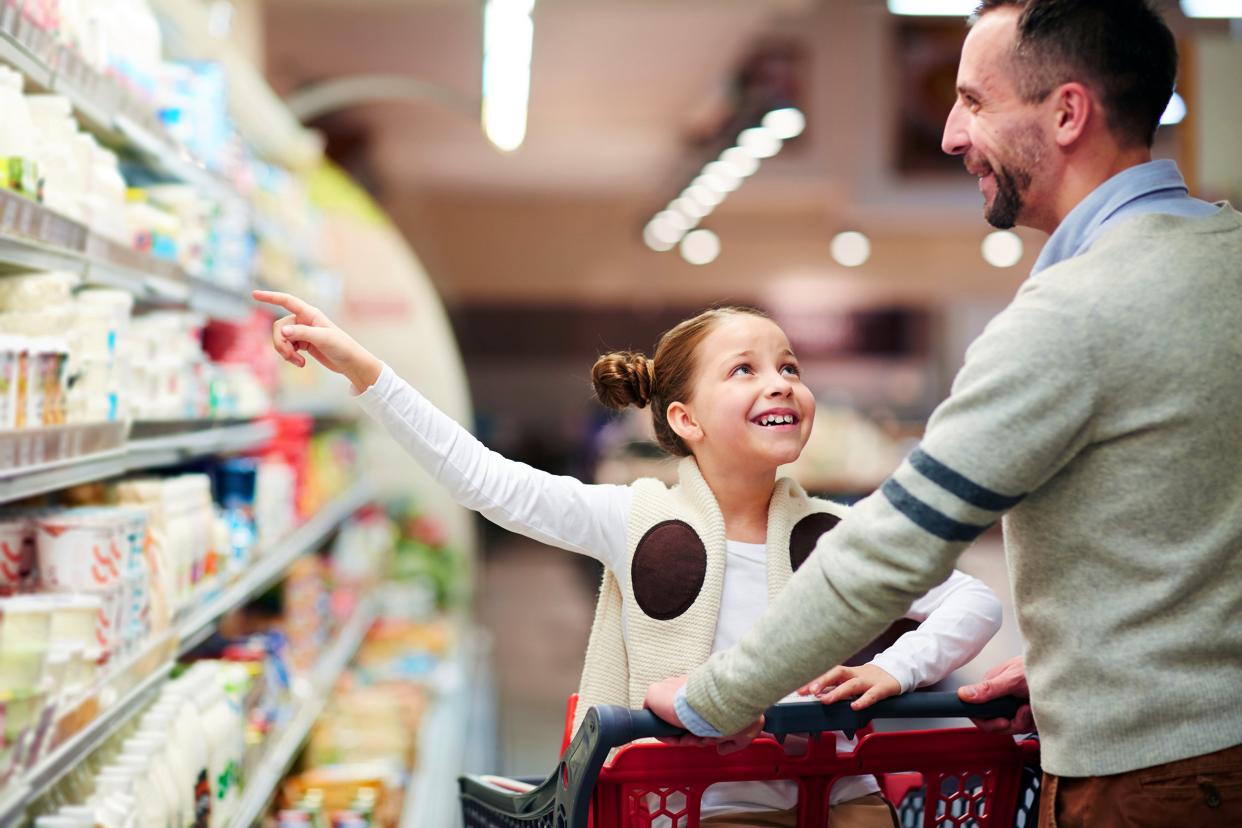 Father and daughter at grocery store and daughter pointing to shelf