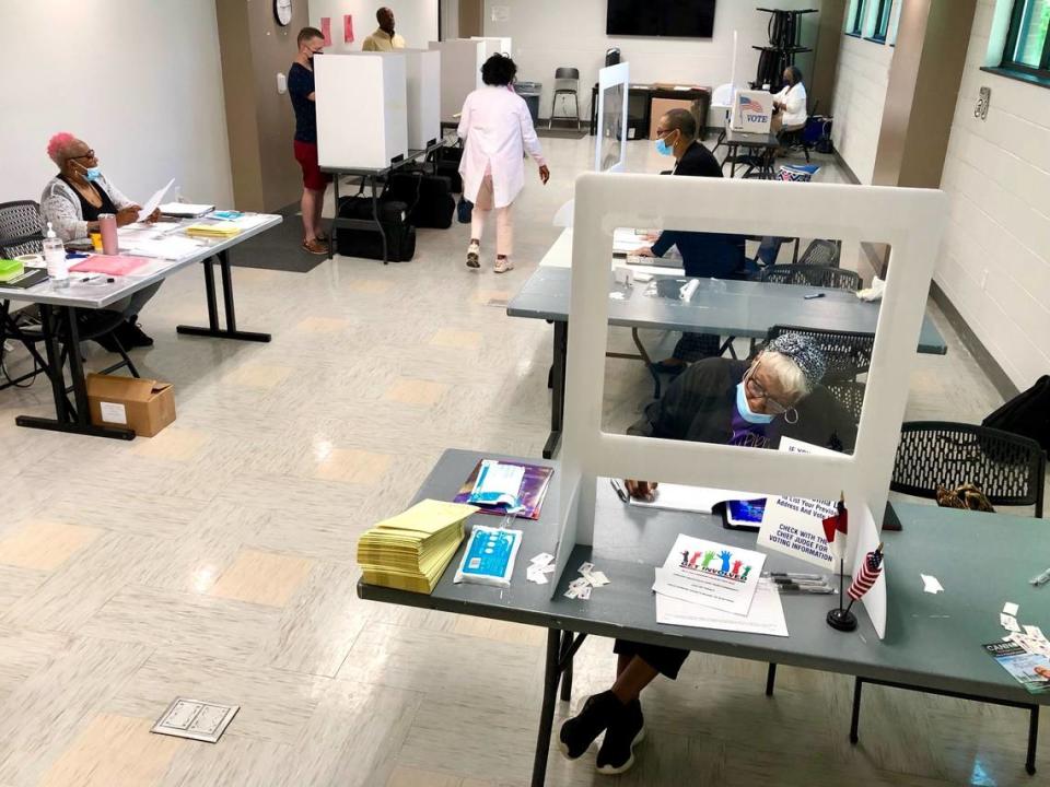 Marge Kennedy, right, an Election Day worker at the West Charlotte Community Center, fills out forms as a voter, center, walks to a booth to cast the ballot on Tuesday, May 17, 2022. The precinct is located along Senior Drive.