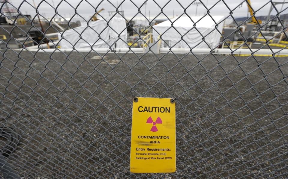FILE - In this March 6, 2013 file photo, a warning sign is shown attached to a fence at the 'C' Tank Farm at the Hanford Nuclear Reservation, near Richland, Wash. Documents obtained by the Associated Press show that there are “significant construction flaws” in some newer, double-walled storage tanks at the nuclear waste complex. (AP Photo/Ted S. Warren, File)