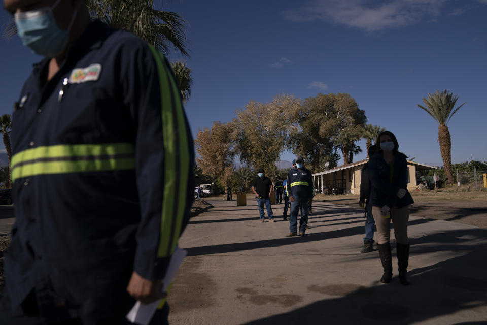 FILE - In this Jan. 21, 2021, file photo, Hispanic farm workers wait in line to receive the Pfizer COVID-19 vaccine in Mecca, Calif. In some California counties, vaccination drives are targeting farmworkers. (AP Photo/Jae C. Hong, File)