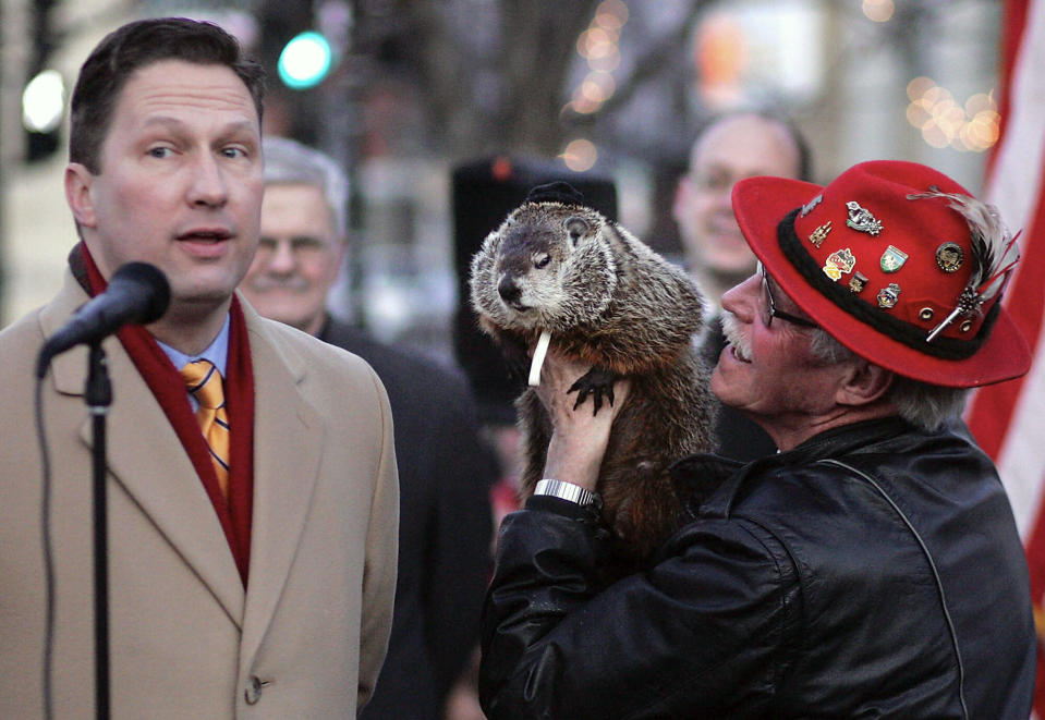 FILE - Sun Prairie Mayor John Murray, left, predicts spring after communicating with Jimmy, Wisconsin's answer to Punxsutawney Phil, held by caretaker Jerry Hahn, in Sun Praire, Wis., Feb. 21, 2012. (Craig Schreiner/Wisconsin State Journal via AP, File)