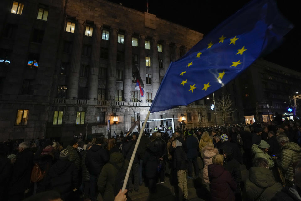 A protester waves an EU flag during protest in front of Serbia's Constitutional Court building in Belgrade, Serbia, Friday, Jan. 26, 2024. More than 1,000 people gathered outside the headquarters of Serbia's Constitutional Court in support of an opposition demand that last month's election be annulled because of widespread irregularities that also were noted by international observers. (AP Photo/Darko Vojinovic)