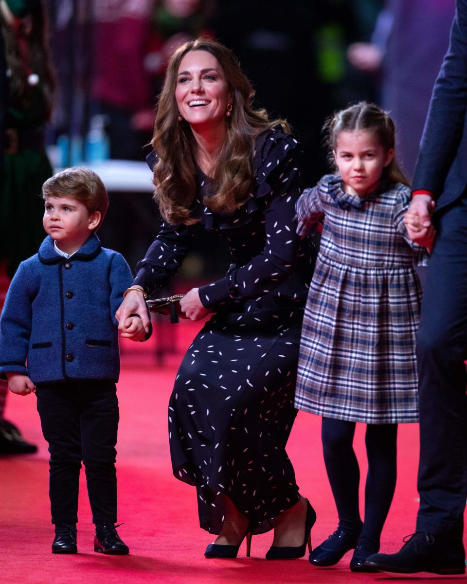 Britain&#39;s Catherine, Duchess of Cambridge (C), holds the hand of her son, Britain&#39;s Prince Louis of Cambridge (L) and her daughter Britain&#39;s Princess Charlotte of Cambridge (R) as they attend a special pantomime performance of The National Lotterys Pantoland  at London&#39;s Palladium Theatre in London on December 11, 2020, to thank key workers and their families for their efforts throughout the pandemic. (Photo by Aaron Chown / POOL / AFP) (Photo by AARON CHOWN/POOL/AFP via Getty Images)
