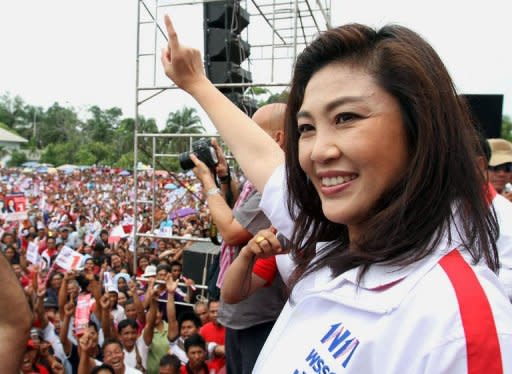 Yingluck Shinawatra (R), sister of fugitive former Thai prime minister Thaksin Shinawatra, waves to supporters during a election campaign rally in Ubonratchathani province, in northeastern Thailand, on June 29, 2011