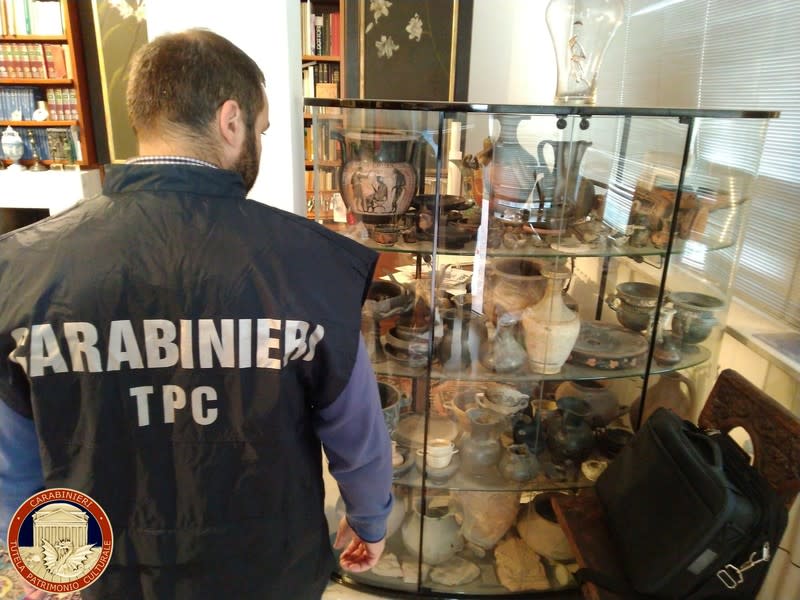 Carabinieri military policeman looks at artefacts in a display case in Cosenza