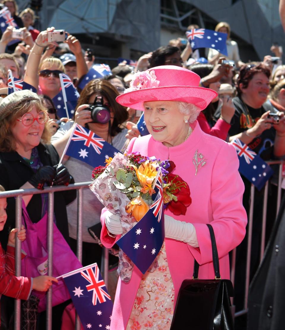 Queen Elizabeth II receives flowers from the crowd during her visit to Federation Square in downtown Melbourne, 2011 (AFP via Getty Images)