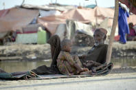 A man takes refuge on a road in Jaffarabad, a flood-hit district of Baluchistan province, Pakistan, Monday, Sept. 19, 2022. Pakistan said Monday there have been no fatalities for the past three days from the deadly floods that engulfed the country since mid-June, a hopeful sign that the nation is turning a corner on the disaster. (AP Photo/Zahid Hussain)