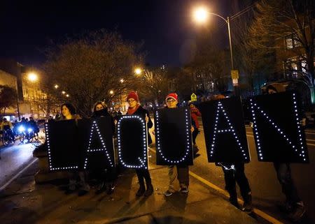 Demonstrators hold signs bearing the name of Laquan McDonald during protests in Chicago, Illinois November 24, 2015 reacting to the release of a police video of the 2014 shooting of a black teenager, Laquan McDonald, by a white policeman, Jason Van Dyke. REUTERS/Jim Young