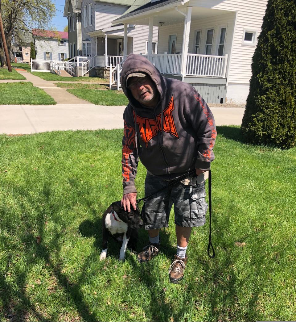 Joe Hicks and his dog Buddy stop for a rest during a walk on Duane Street in Hornell, April 28, 2022. Hicks adopted the one-year-old mix breed from the Hornell Area Humane Society earlier in April.