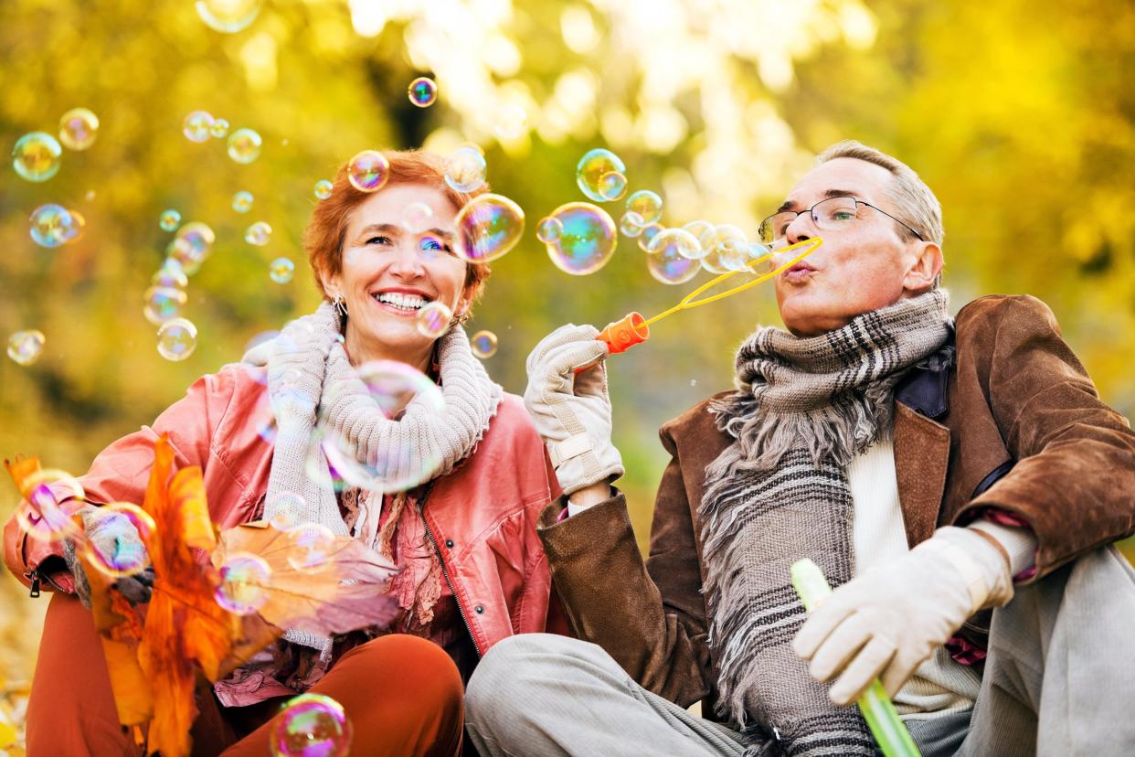 Senior couple blowing bubbles outside