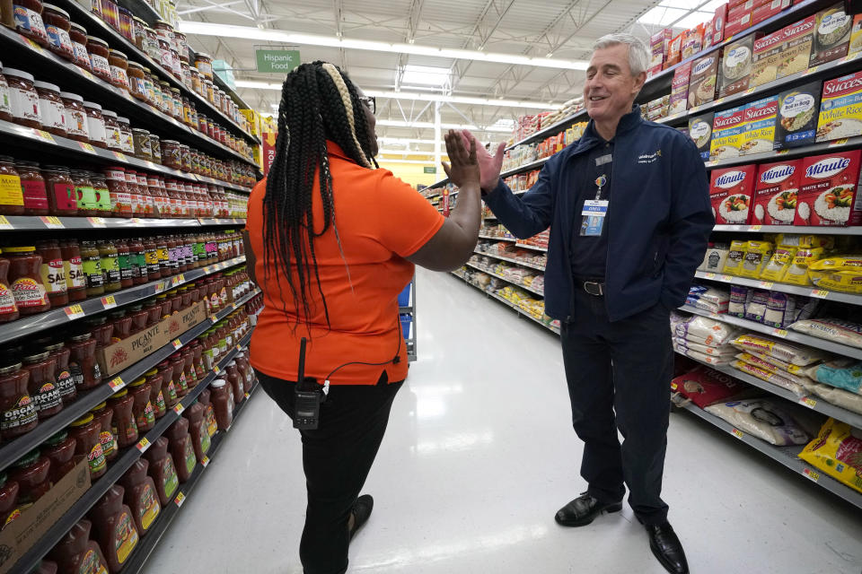 In this Friday, Nov. 9, 2018, photo Walmart U.S. President and CEO Greg Foran, right, high-fives associate Alicia Carter as she fulfills online grocery orders at a Walmart Supercenter in Houston. Foran took over as CEO of the discounter’s U.S. division four years ago. (AP Photo/David J. Phillip)