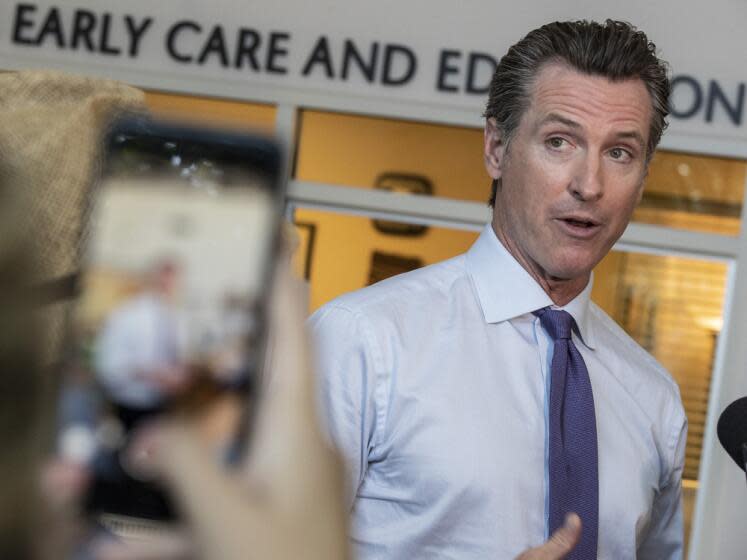 A staff member shoots a video of Gavin Newsom