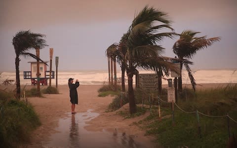 A woman takes a picture as the effects of Hurricane Dorian begin to be felt on Monday in Cocoa Beach, Florida - Credit: Scott Olson/Getty Images North America