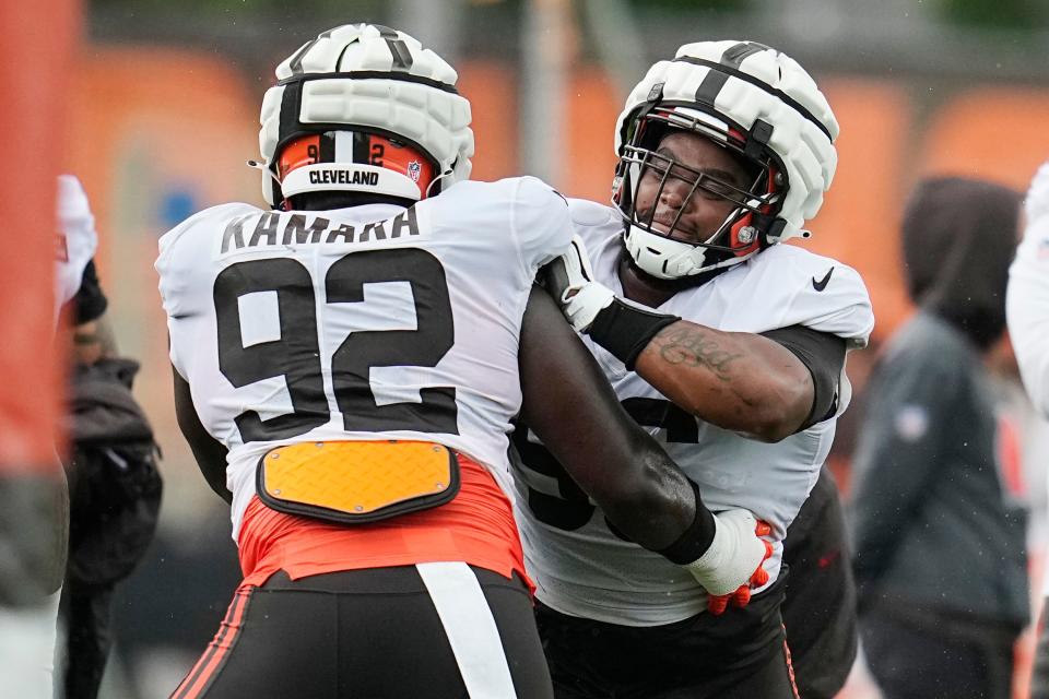 Cleveland Browns linebacker Sam Kamara (92) and defensive tackle Jordan Elliott, right, participate in a drill during an NFL football camp, Monday, Aug. 7, 2023, in Berea, Ohio. (AP Photo/Sue Ogrocki)