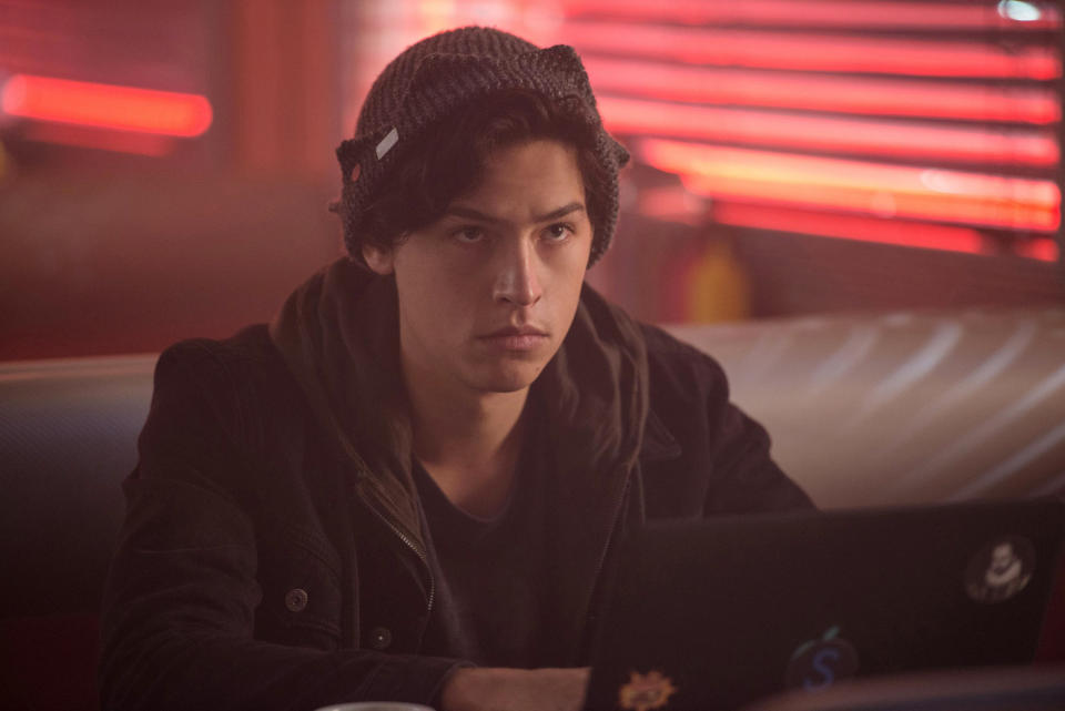 Cole Sprouse sitting at a diner in "Riverdale"