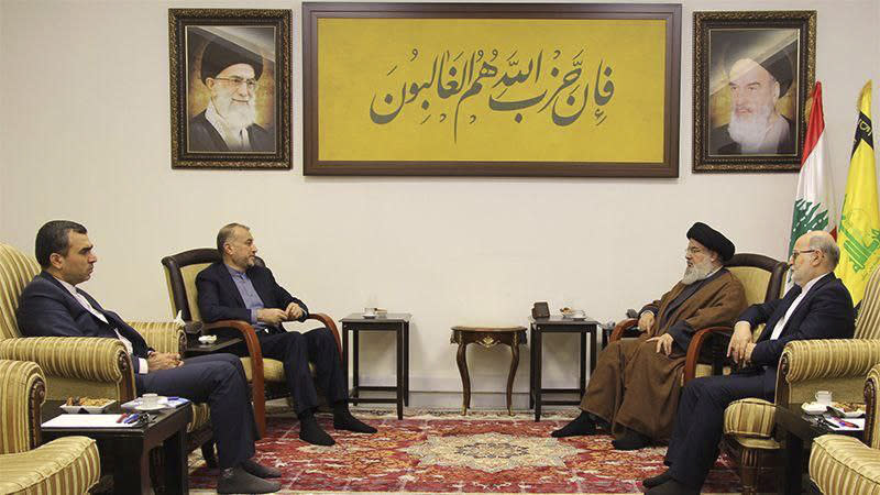 In this picture released by the Iranian Foreign Ministry on Thursday, Nov. 23, 2023, Iran's Foreign Minister Hossein Amirabdollahian, second left, speaks with Lebanese Hezbollah leader Sayyed Hassan Nasrallah, second right, under the photos of the late Iranian revolutionary founder Ayatollah Khomeini, right, and Supreme Leader Ayatollah Ali Khamenei, in Beirut, Lebanon. The writing on top center reads a verse of Quran in Arabic: "it is the fellowship of Allah that must certainly triumph". (Iranian Foreign Ministry via AP)
