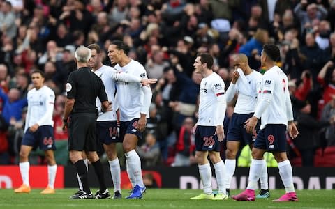 Liverpool surround the referee - Credit: AFP