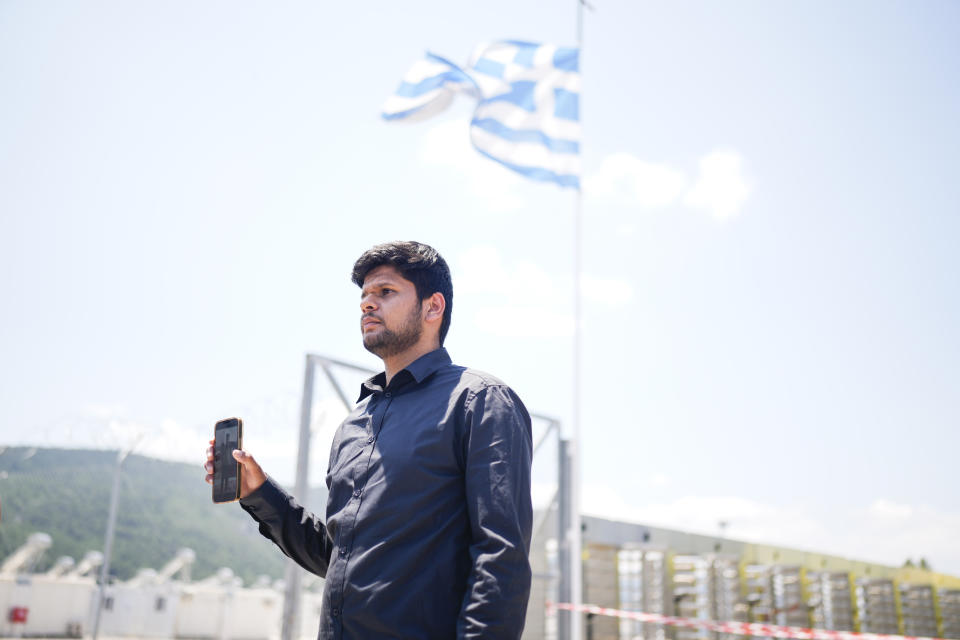 Zohaib Shamraiz holds up a photograph of his uncle missing uncle, Nadeem Muhamm, outside a migrant camp in Malakasa north of Athens, on Monday, June 19, 2023. Hundreds of migrants are believed to be missing after a fishing trawler sank off southern Greece last week. (AP Photo/Petros Giannakouris)