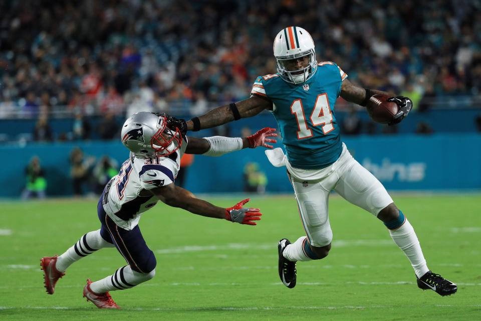 MIAMI GARDENS, FL - DECEMBER 11: Jarvis Landry #14 of the Miami Dolphins tries to avoid the tackle of Jonathan Jones #31 of the New England Patriots in the first quarter at Hard Rock Stadium on December 11, 2017 in Miami Gardens, Florida. (Photo by Mike Ehrmann/Getty Images)