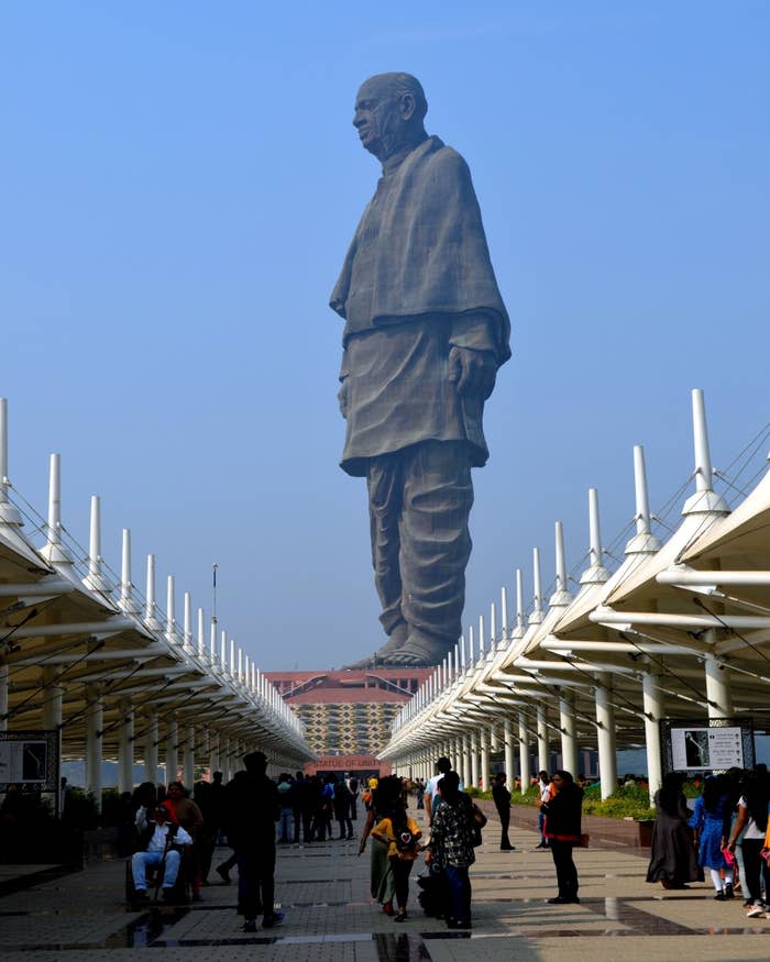 A large crowd visiting the Statue of Unity, a monumental statue of Sardar Vallabhbhai Patel in India, situated between two rows of covered walkways