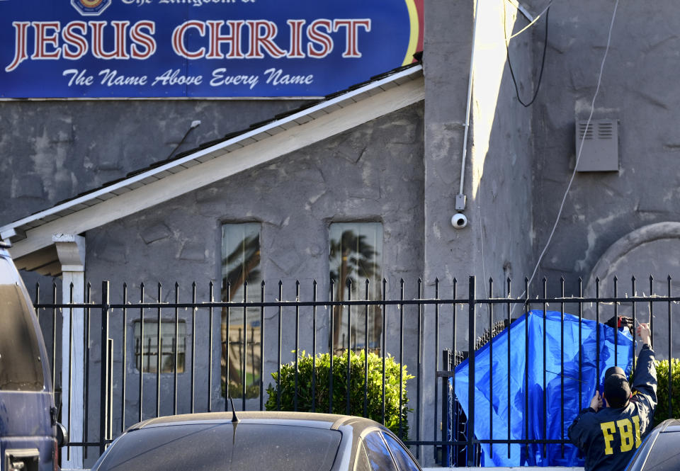 FBI agents cover a fence on the grounds of the Kingdom of Jesus Christ Church in the Van Nuys section of Los Angeles on Wednesday, Jan. 29, 2020. The FBI raided a Philippines-based church in Los Angeles to arrest leaders of an alleged immigration fraud scheme that resulted in sham marriages. Federal prosecutors said Wednesday that three leaders of the local branch of the Kingdom of Jesus Christ were arrested in morning raids. (AP Photo/Richard Vogel)