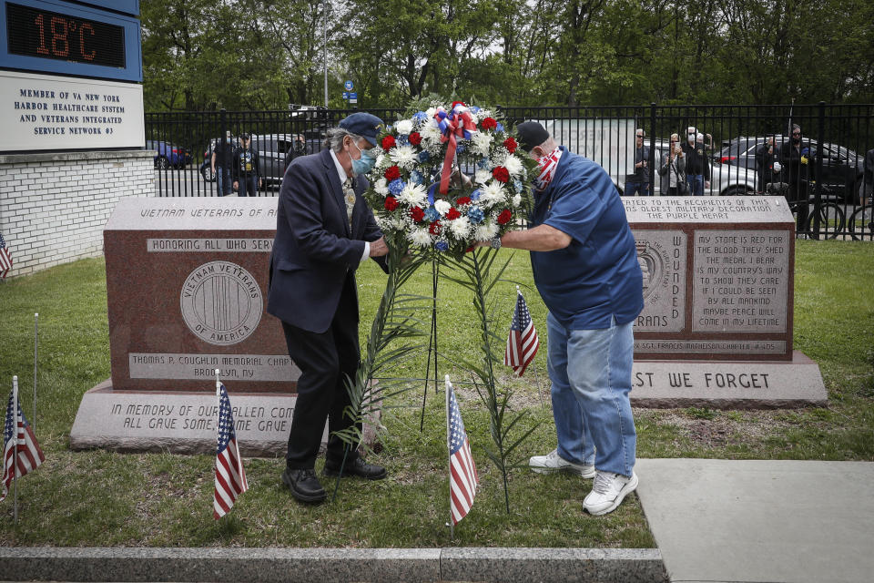 A motorcade of veterans stops outside the VA Medical Center as wreaths are lain beside memorial stones on the premises, Monday, May 25, 2020, in the Brooklyn borough of New York. (AP Photo/John Minchillo)