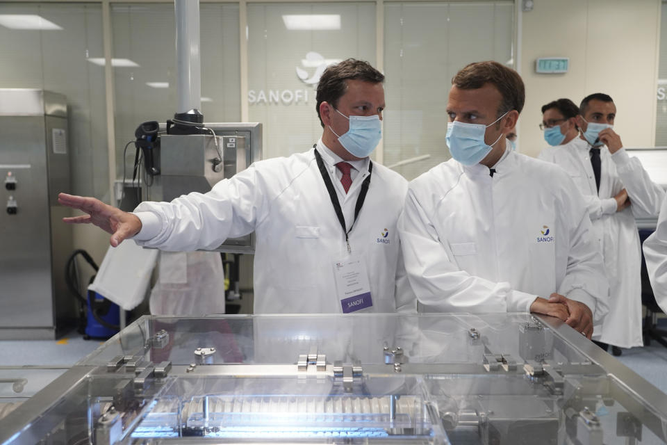 French President Emmanuel Macron listens to researchers as he visits an industrial development laboratory at French drugmaker's vaccine unit Sanofi Pasteur plant in Marcy-l'Etoile, near Lyon, central France, Tuesday, June 16, 2020.The visit comes after rival pharmaceutical company AstraZeneca this weekend announced a deal to supply 400 million vaccine doses to EU countries, including France. (AP Photo/Laurent Cipriani, Pool)