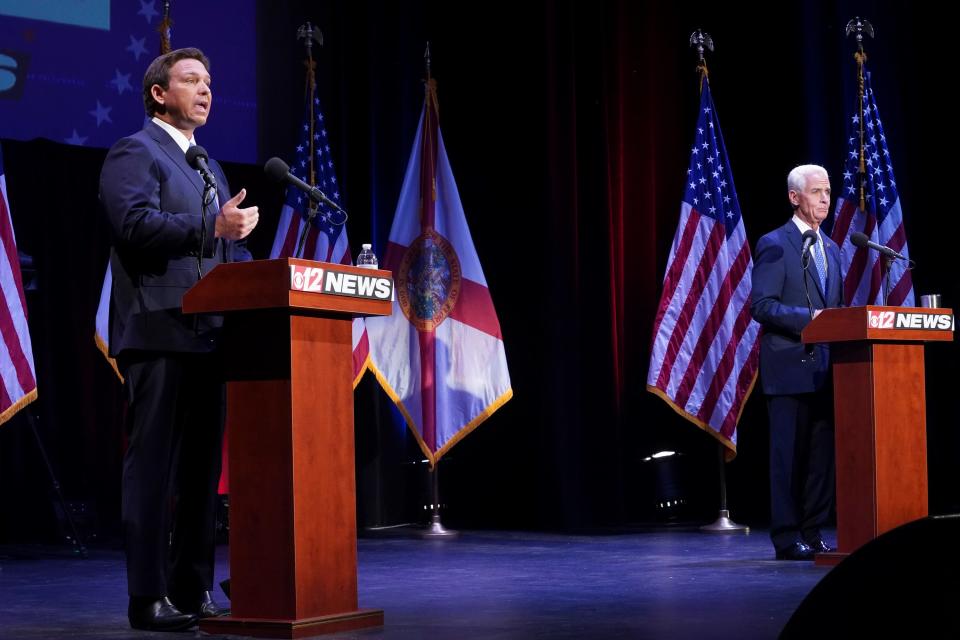 Florida's Republican incumbent Gov. Ron DeSantis and Charlie Crist, a former governor, take the stage at Sunrise Theatre for their only scheduled debate, on Monday in Fort Pierce, Fla.