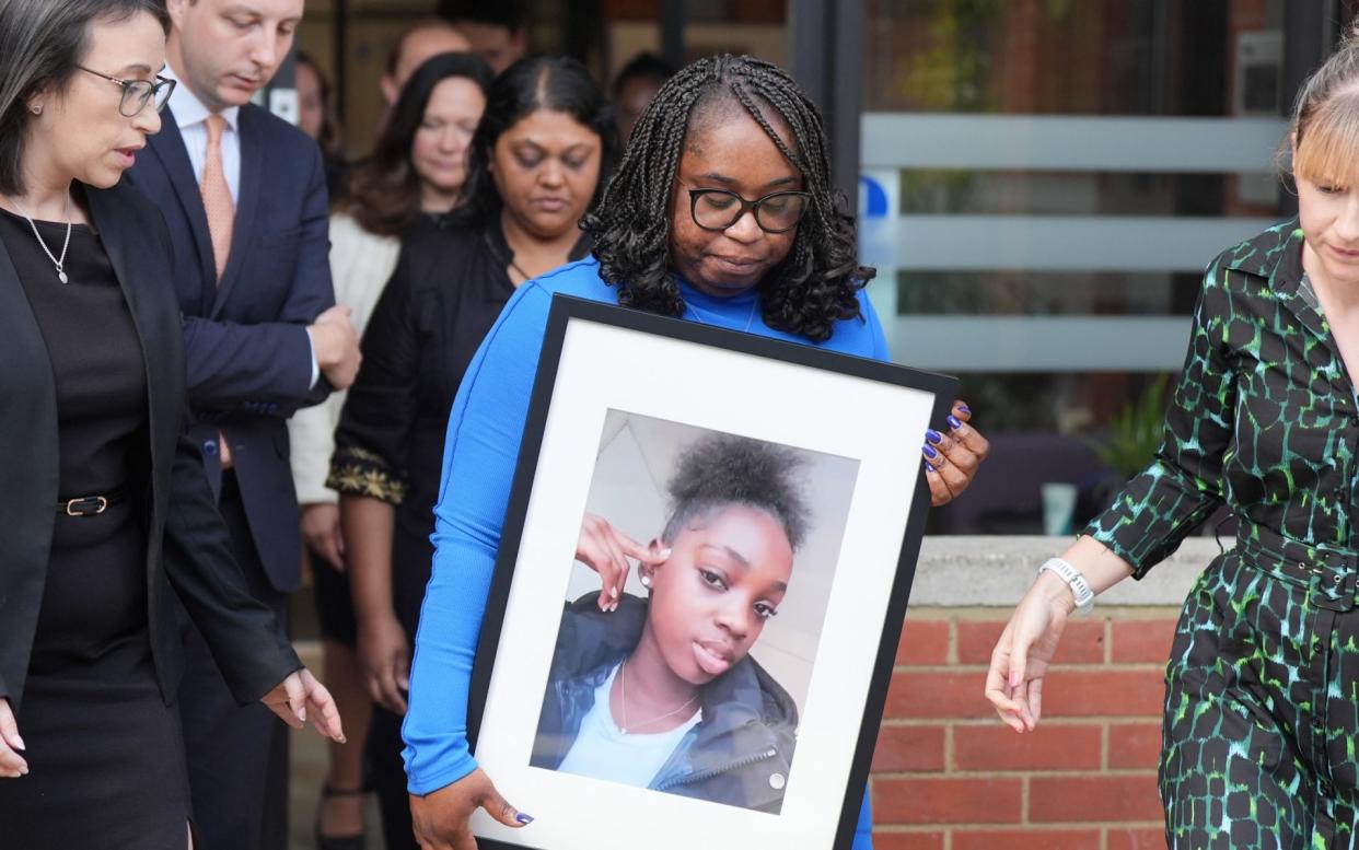 Hannah Jacobs's mother carries a picture of her daughter outside East London Coroner's Court