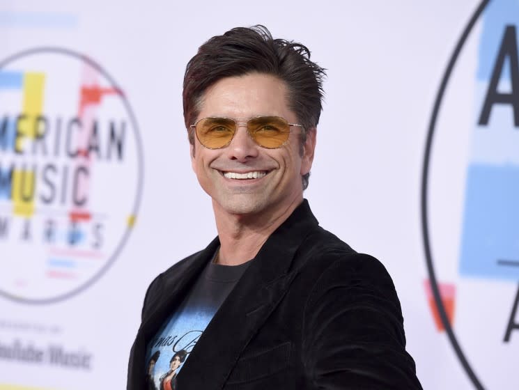 John Stamos arrives at the American Music Awards on Tuesday, Oct. 9, 2018, at the Microsoft Theater in Los Angeles. (Photo by Jordan Strauss/Invision/AP)