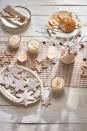 <p>Forget red and green — this understated tablescape relies on muted tones, beaded decorations, and natural beauty (think: twigs and acorns).</p>