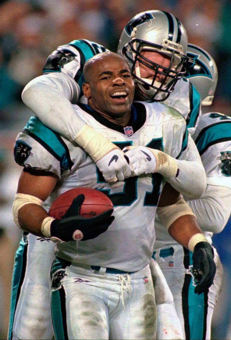 FILE - Carolina Panthers linebacker Sam Mills, front, celebrates with teammate Matt Elliott after his interception in the final moments of the Panthers' 26-17 win over the Dallas Cowboys at Ericsson Stadium in Charlotte, N.C., in this Sunday Jan. 5, 1997, file photo. Mills is a 2021 finalist for entry into the Pro Football Hall of Fame. (AP Photo/Chuck Burton, File)