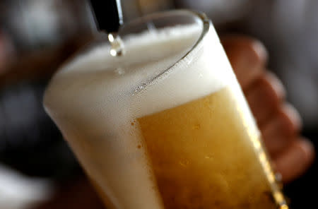 FILE PHOTO: A pint of beer is poured into a glass in a bar in London, Britain June 27, 2018. REUTERS/Peter Nicholls/File Photo