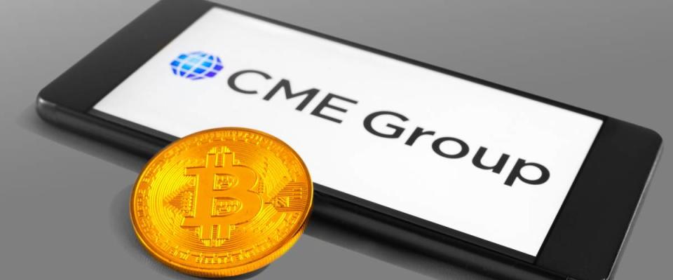 CME Group logo on a mobile device with Bitcoin coin