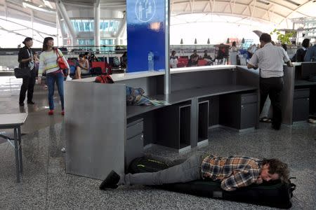 A man sleeps on the floor of the Ngurah Rai airport following his flight being cancelled in Bali, November 4, 2015 in this picture taken by Antara Foto. REUTERS/Nyoman Budhiana/Antara Foto