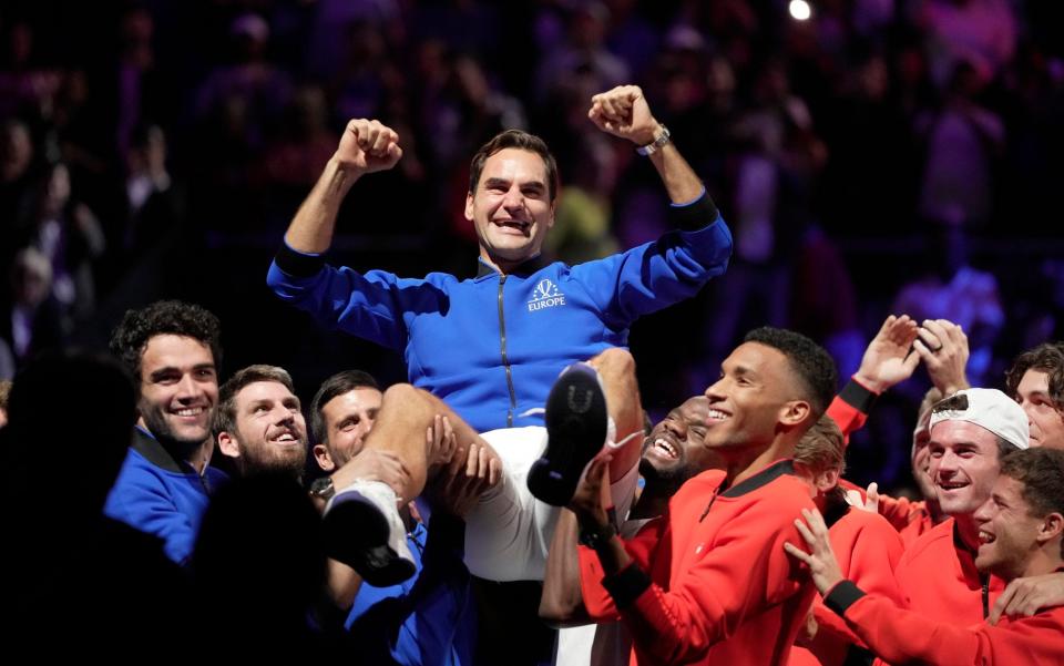 The teams combined to carry Federer aloft after the match - AP