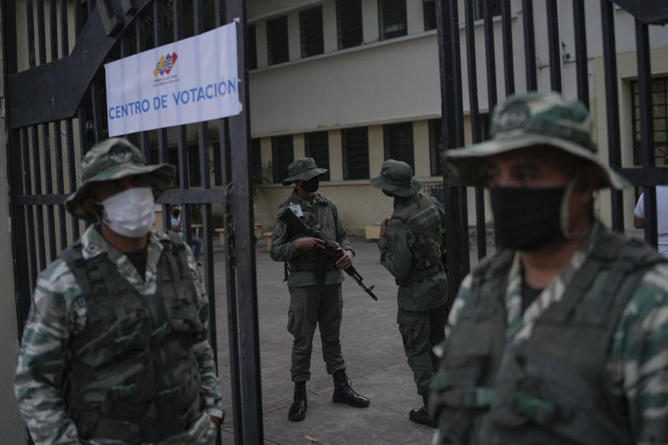 Soldiers guard polling station during an election re-run to decide the governor in Barinas, Venezuela, Sunday, Jan. 9, 2022. Voters in the home state of the late Venezuelan President Hugo Chávez are voting again Sunday in a special gubernatorial election called after the opposition contender in November’s regular contest was retroactively disqualified as he was ahead in the vote count. (AP Photo/Matias Delacroix)