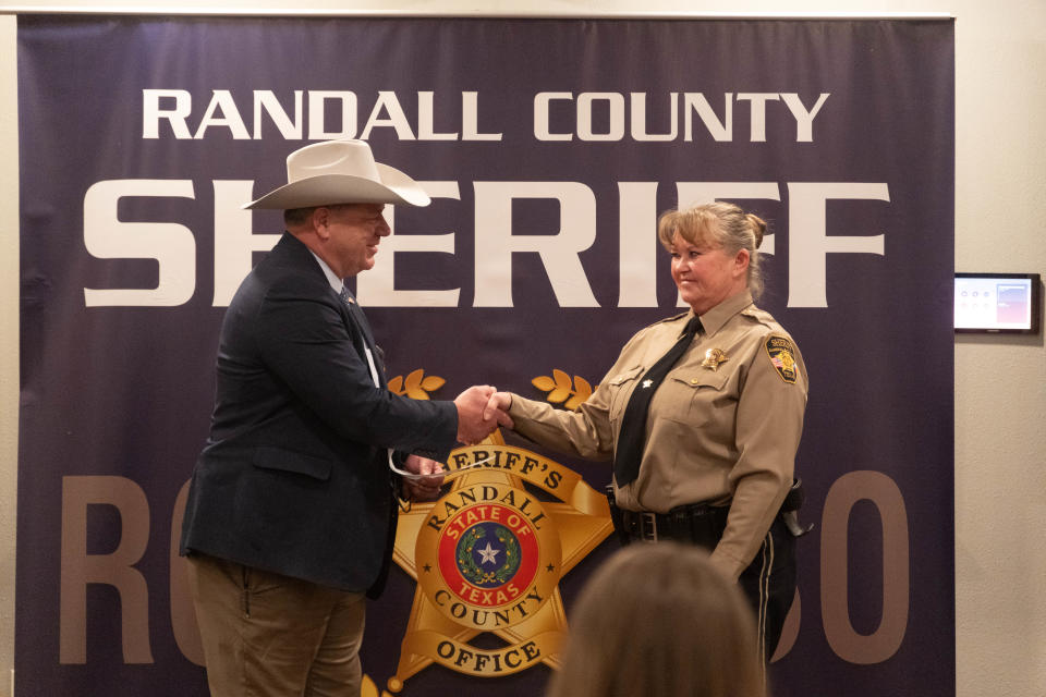 Randall County Sheriff Christopher Forbis presents Officer Shawntae Moeller an award recognizing her years of services Thursday at the Randall County Sheriff's Office outside of Amarillo.