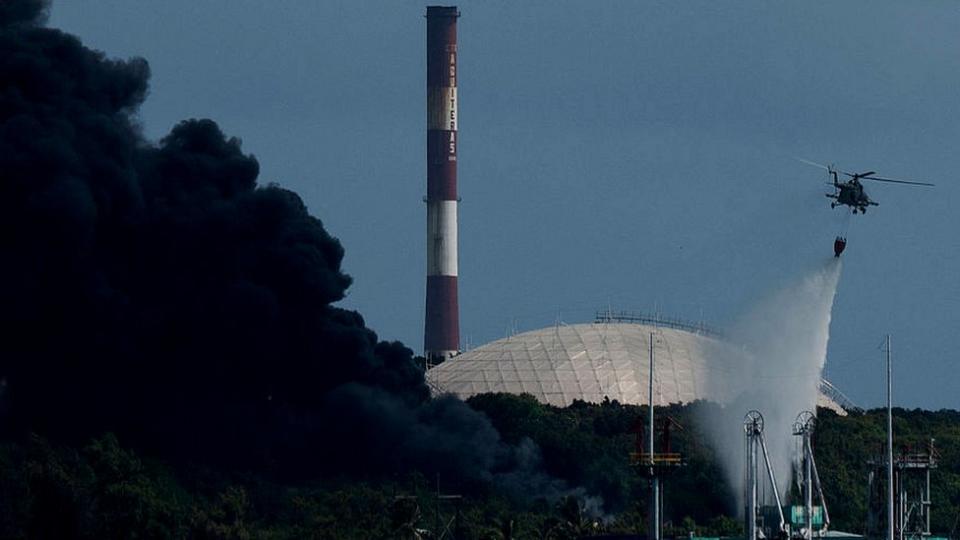 Un helicóptero derrama agua sobre el incendio producido por el impacto de un rayo sobre un tanque de combustible, en la ciudad de Matanzas, a 130 km al este de La Habana.