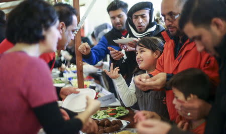 Migrants receive food at a Christmas market in a refugee shelter run by German charity organisation Arbeiter Samariter Bund ASB in Berlin, Germany, December 12, 2015. REUTERS/Hannibal Hanschke