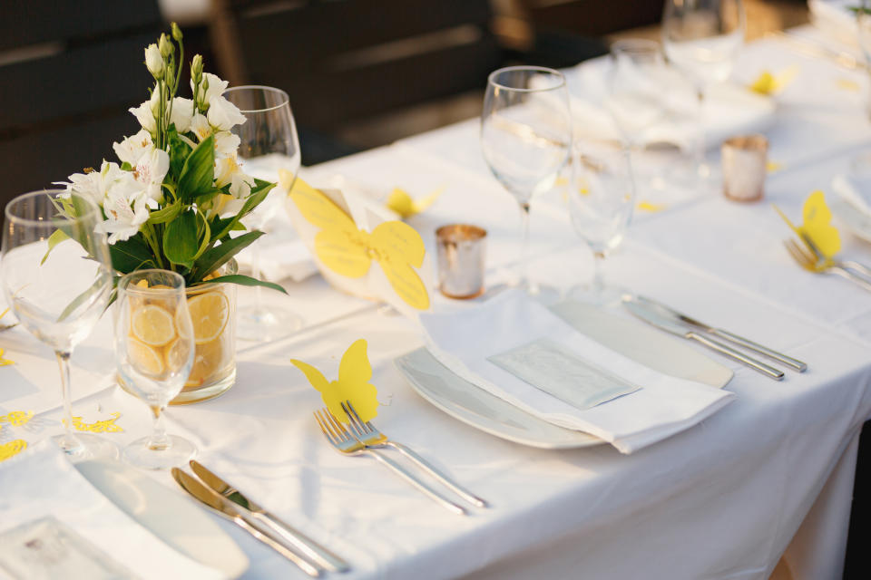 Elegant table setting for an event with floral centerpiece and butterfly decorations