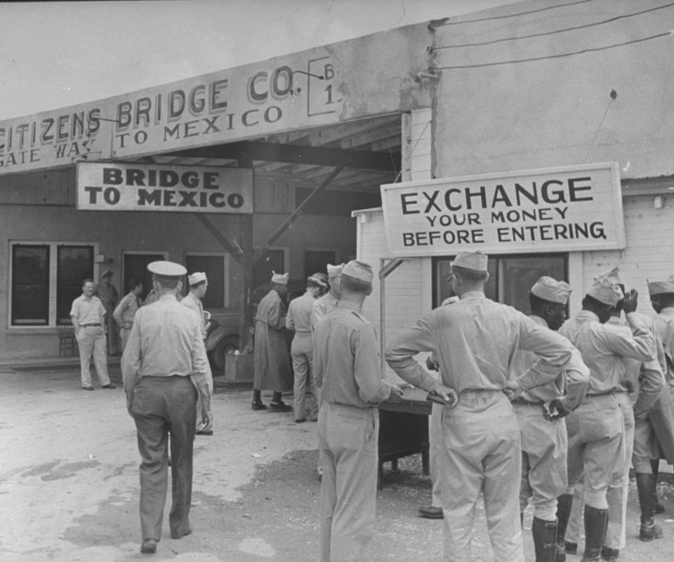 U.S. soldiers exchanging money at the U.S.-Mexico border.