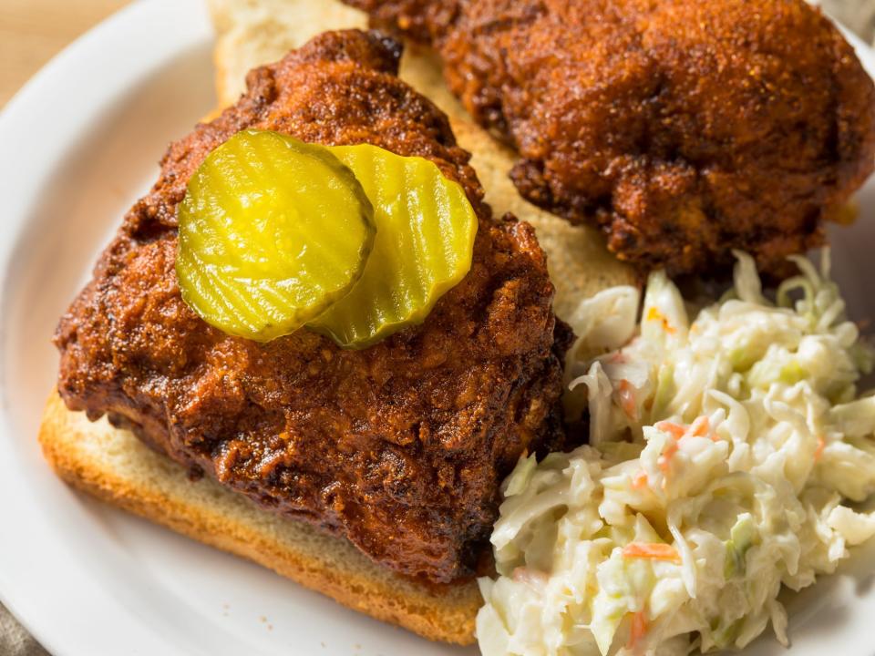 Nashville hot chicken with pickles and coleslaw on white bread