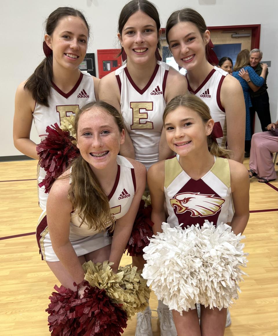 Cheerleaders smiling after performing in their new gym.