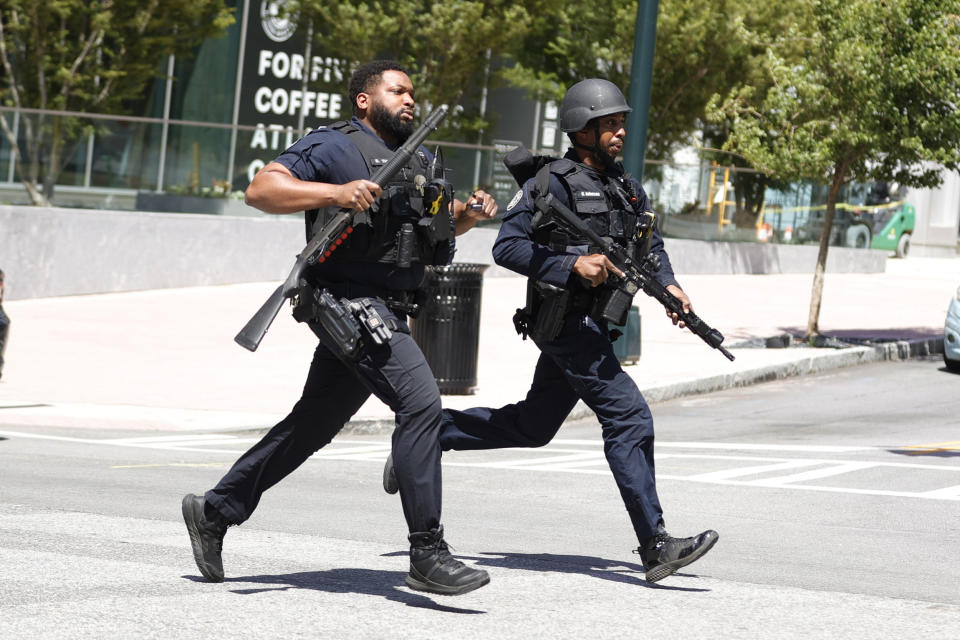 Law enforcement officers run near the scene of an active shooter on Wednesday, May 3, 2023 in Atlanta. Atlanta police said there had been no additional shots fired since the initial shooting unfolded inside a building in a commercial area with many office towers and high-rise apartments.   (Alex Slitz / AP)