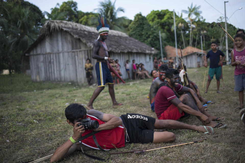 In this Sept. 3, 2019 photo, a man takes a picture during a meeting of Tembé tribes in Tekohaw indigenous reserve, Para state, Brazil. (Brazil’s 900,000 indigenous people make up about 5% of the country’s percent of all of the population and their reservations account for about 14 percent of the country. (AP Photo/Rodrigo Abd)